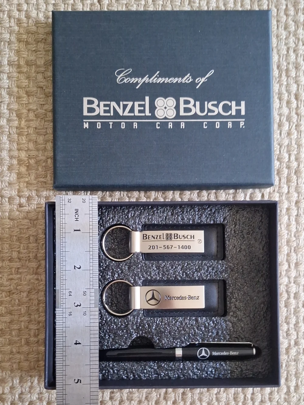 The seMercedes-Benz branded gift set featuring two keychains and a ballpoint pen